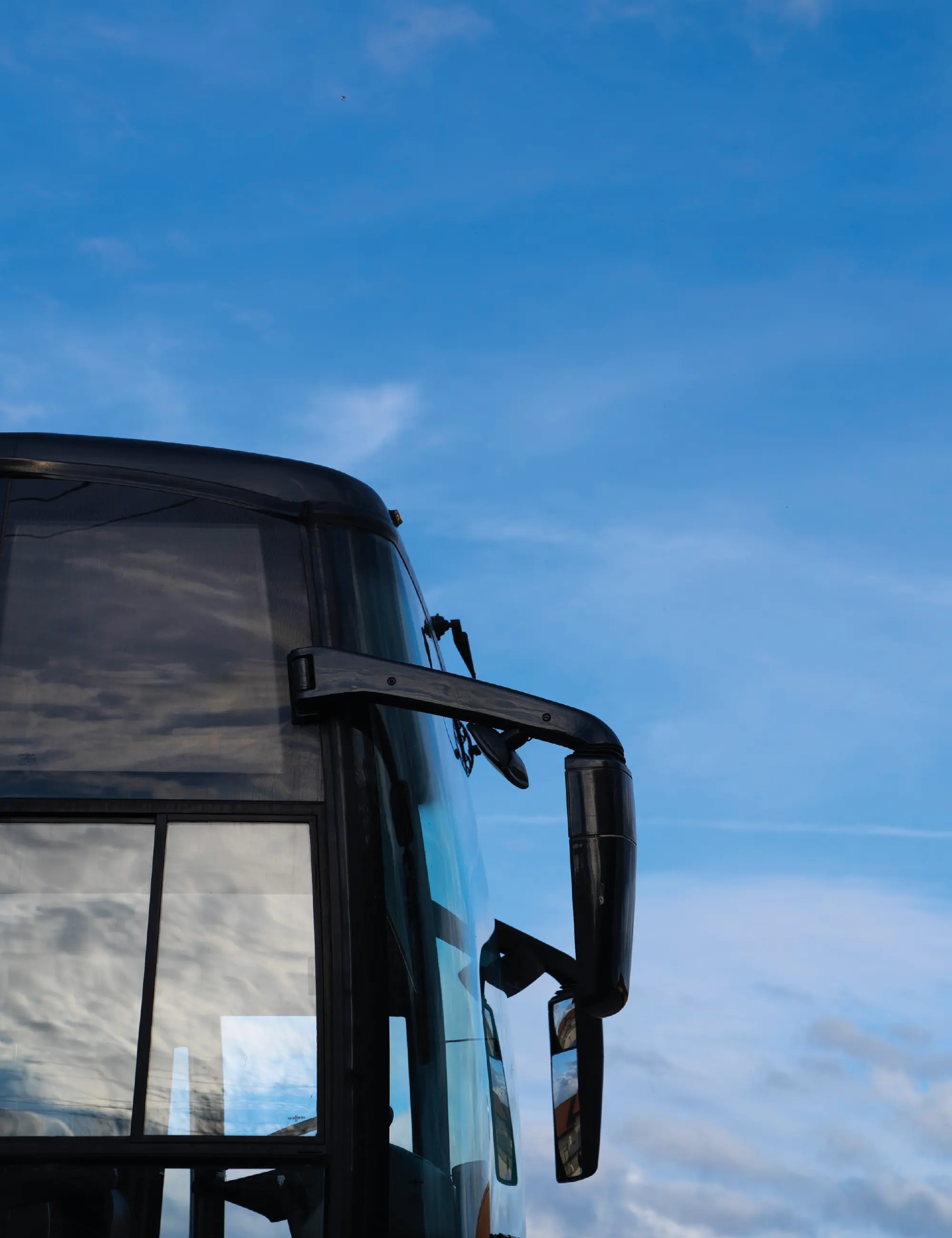 Aperçu de la cabine d'un autocar de l'extérieur, avec le ciel bleu derrière