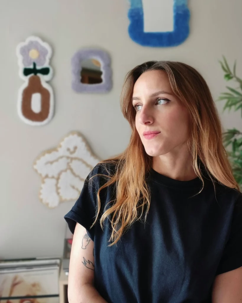 Portait de Clarisse Joly avec en arrière-plan ses créations en tufting Lyon