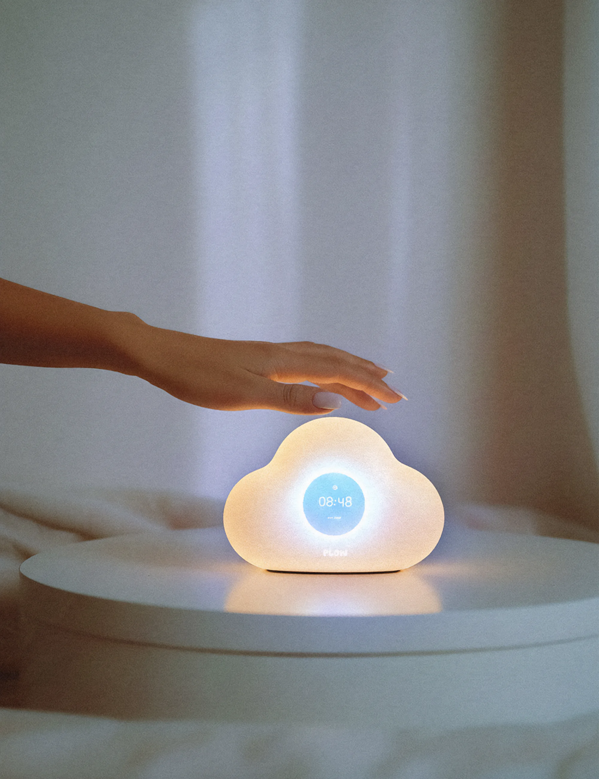 La veilleuse plow est posée sur une table de nuit, et une main de femme est au-dessus. Réinventez vos nuits, par Clarisse Joly (rvb challenge)