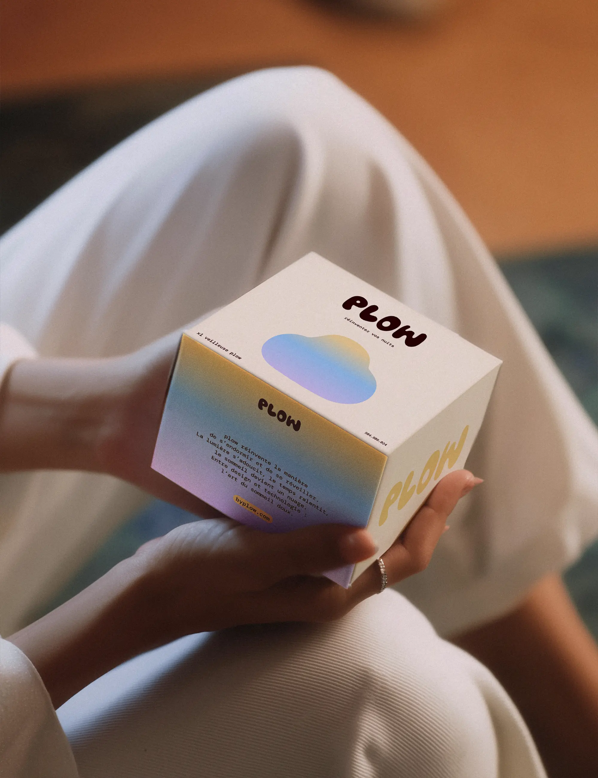 Aperçu du packaging de la veilleuse nuage de la marque plow, posé sur une table en verre, par Clarisse Joly (rvb challenge)